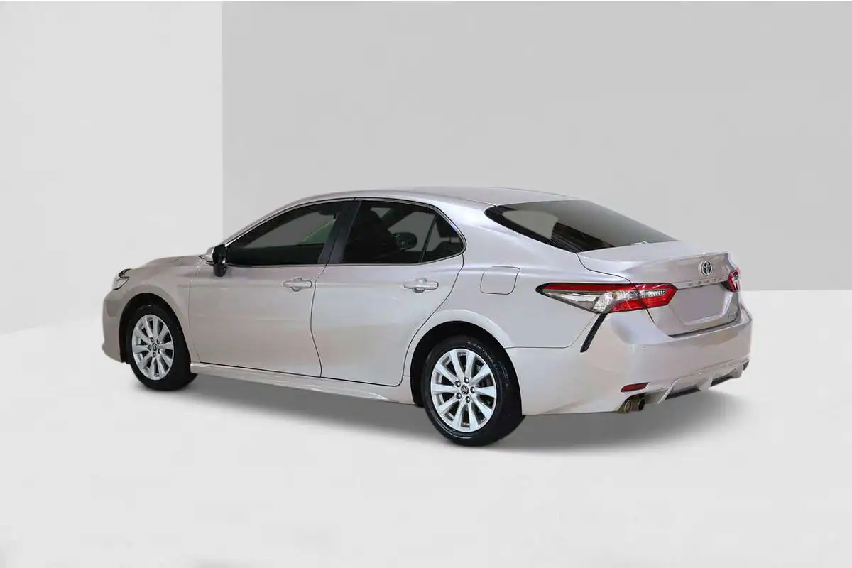 Silver Toyota Camry rear three-quarter enhanced on studio backdrop